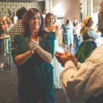 groupe de personnes qui se regardent et dansent dans une salle lors d'un mariage