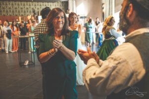 groupe de personnes qui se regardent et dansent dans une salle lors d'un mariage